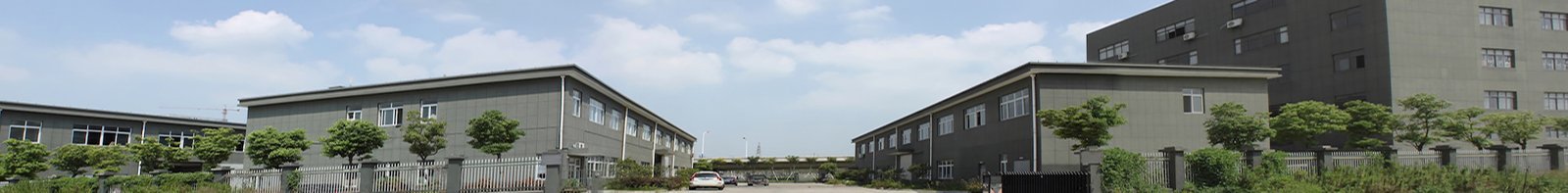 A view of a building with a fence and trees.